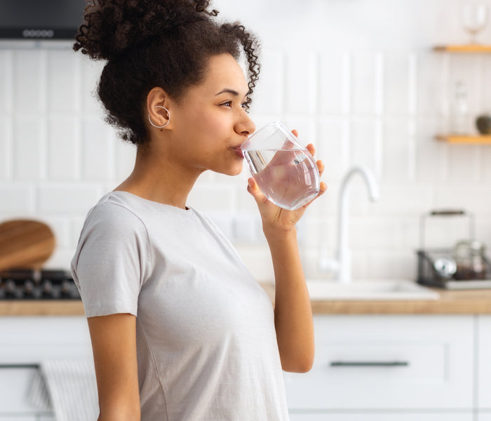 woman drinking water from glass